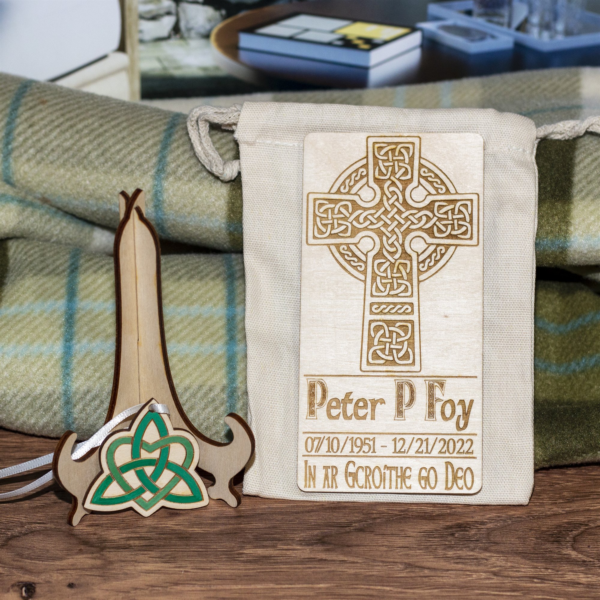 A Celtic cross memorial keepsake engraved with a name, dates and a line in Irish