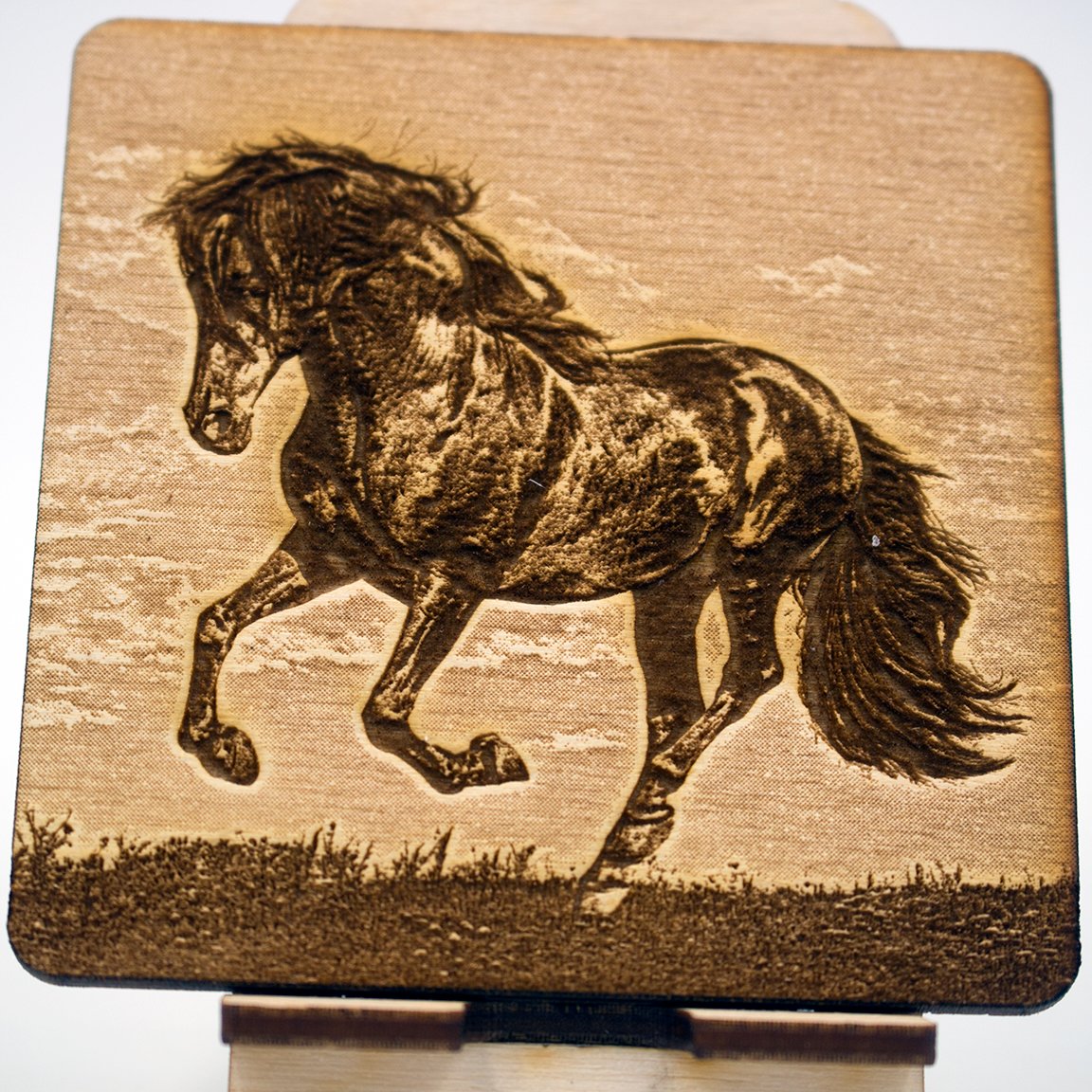 Photo engraving of a dark horse galloping, its mane and tail flying